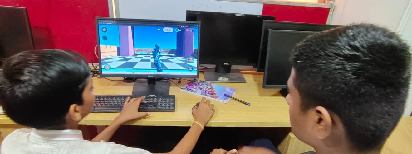 Two students, seen from behind, work together at a computer running Learnverse.